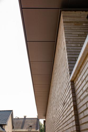 Wohnhaus mit Flachdach, Eingangsbereich mit Flachdachziegeln Dachrandprofil und Untersichtbekleidung in Farbe DB703